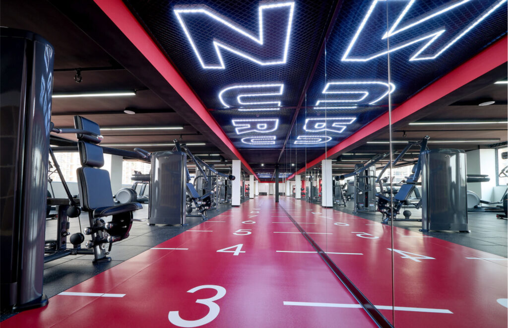 ZURU branded gym, numerous weight lifting and workout machines in foreground