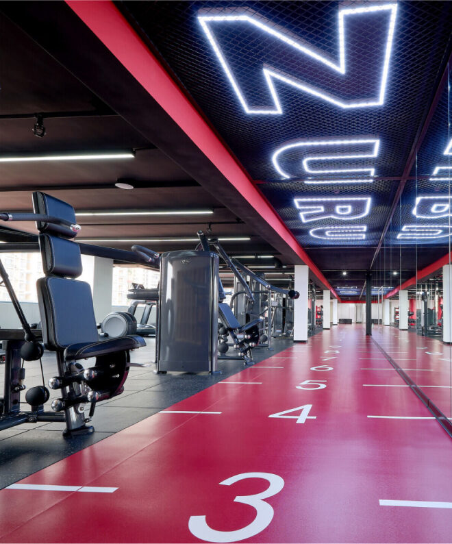 ZURU branded gym, numerous weight lifting and workout machines in foreground